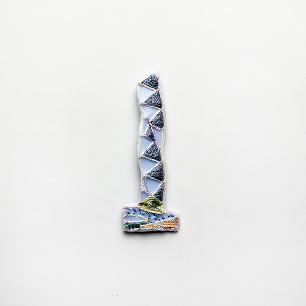 B1 タワーブローチ〈シルバー×クリアピンク〉<br>制作者:Kimiko Sekine<br>サイズ:7cm×2.5cm<br>素材:布、PPシート、フェルト、刺繍糸、ブローチピン<br><br>水戸芸術館のタワーはいつも変わらず佇んでいますが、いつも違ってみえます。このブローチはうららかなたたずまいのタワーをイメージして作りました。