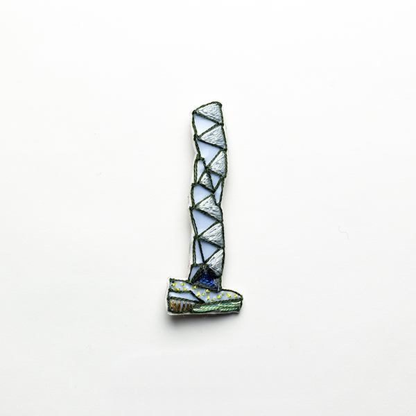 B4 タワーブローチ〈シルバー×ダークグレー〉<br> 制作者:Kimiko Sekine<br>サイズ:7cm×2.5cm<br>素材:布、PPシート、フェルト、刺繍糸、ブローチピン<br><br>水戸芸術館のタワーはいつも変わらず佇んでいますが、いつも違ってみえます。このブローチは穏やかで落ち着きのあるタワーをイメージして作りました。