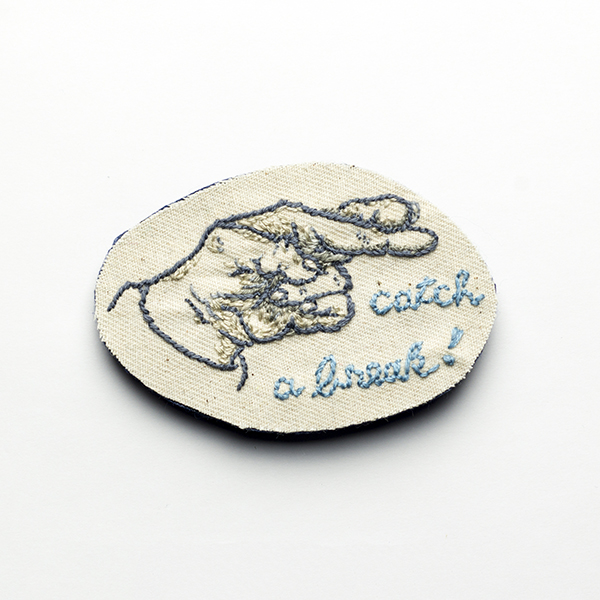B15 Fingers crossed<br>制作者:わたげ<br>サイズ:5cm×7.5cm<br>素材:刺繍糸、布、フェルト、ブローチピン<br><br>Good Luckを意味するハンドサインと、好機を掴むというフレーズ。 コロナ禍で、できないこと、我慢すべきことを数え上げてしまいますが、この状況だからこそできることを見つけたい。自分へのエールです。 自分の手をデッサンしました。