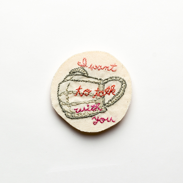 B16 あなたと話したい<br>制作者:わたげ<br>サイズ:5cm×5cm<br>素材:刺繍糸、布、フェルト、ブローチピン<br><br>マスクと”I want to talk with you”。 マスクをせずにテニスをしていた時、通りがかりの方がボールを拾ってくれた。大きな声でありがとうと言いたかったのに、飛沫を気にして言い淀んでしまった。 目の前のあなたと話したいから私はマスクをします、というメッセージ。