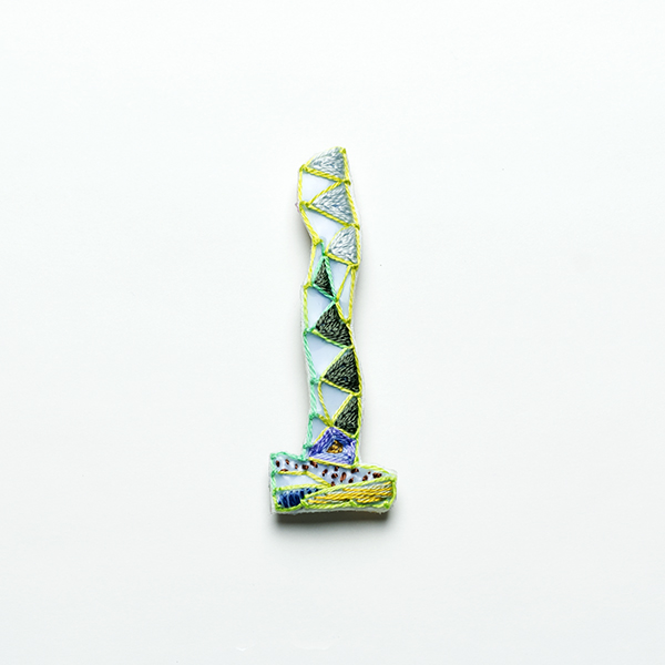 B22 タワーブローチ〈シルバー/スモークグレー×ミントブルー〉<br>制作者:Kimiko Sekine<br>サイズ:7cm×2.5cm<br>素材:布、PPシート、フェルト、刺繍糸、ブローチピン<br><br>水戸芸術館のタワーはいつも変わらず佇んでいますが、いつも違ってみえます。このブローチはセキレイの道案内を見守るタワーをイメージして作りました。