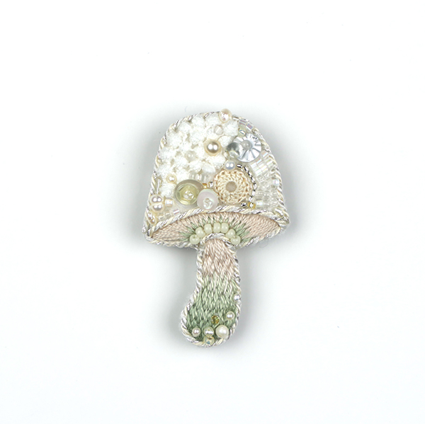 B309 侵蝕されたキノコのブローチ(土)<br>制作者:itoko<br>サイズ:6cm×3.5cm<br>素材:フェルト、刺繍糸、組紐、ビーズ、スパンコール、淡水パール、レース、ブローチピン<br><br>自分以外の他の菌に蝕まれてしまったキノコのブローチです。