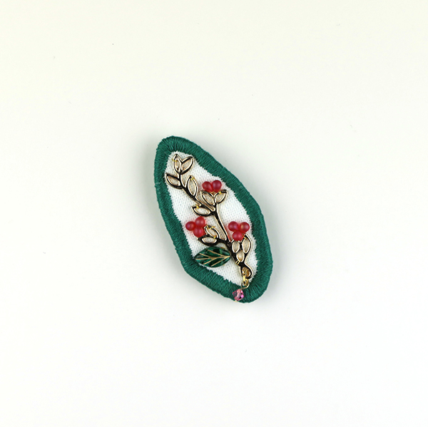 B597 集合体(ローズ)<br>制作者:Sukesan<br>サイズ:4cm×4.5cm<br>素材:布、フェルト、刺繍糸、メタルパーツ、チェコビーズ、スワロフスキー(ローズ)、合成皮革、ブローチピン<br><br>植物も人間社会もいろいろなモノ達が集まって造られているんですよね。