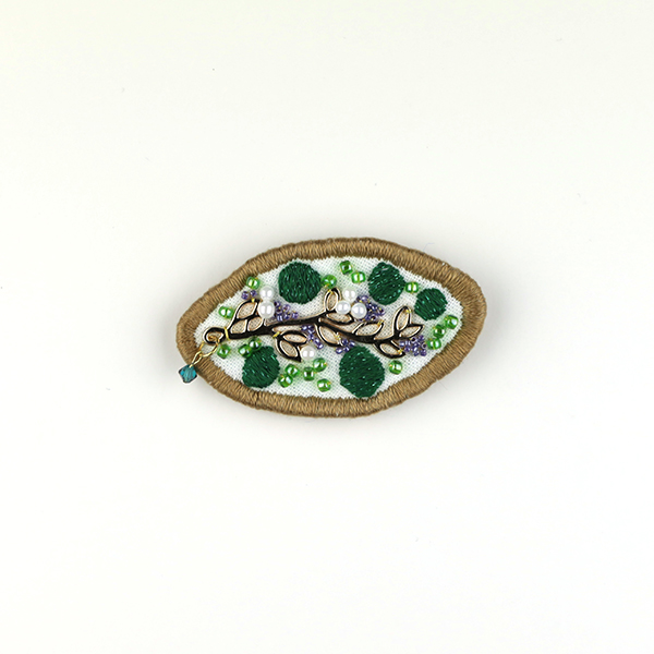 B598 集合体(ジルコニア)<br>制作者:Sukesan<br>サイズ:3.7cm×6.4cm<br>素材:布、フェルト、刺繍糸、メタルパーツ、ビーズ、チェコビーズ、スワロフスキー(ジルコニア)、合成皮革、ブローチピン<br><br>植物も人間社会もいろいろなモノ達が集まって造られているんですよね。