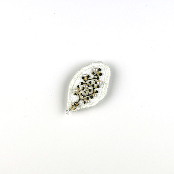 B606 葉 -White-<br>制作者:Sukesan<br>サイズ:3.7cm×3.3cm<br>素材:布、フェルト、刺繍糸、メタルパーツ、プラスチックパール、スワロフスキー(クリスタル)、合成皮革、ブローチピン<br><br>ピカピカの葉っぱです。