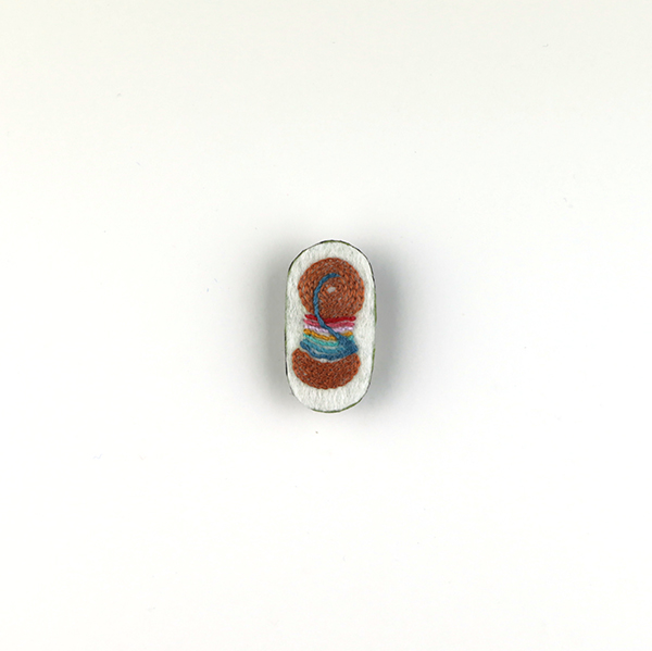 B621 糸まきブローチ<br>制作者:Tono Tono<br>サイズ:3.5cm×2cm<br>素材:フェルト、刺繡糸、ビーズ、ブローチピン<br><br>7色の糸をまきつけた糸まき