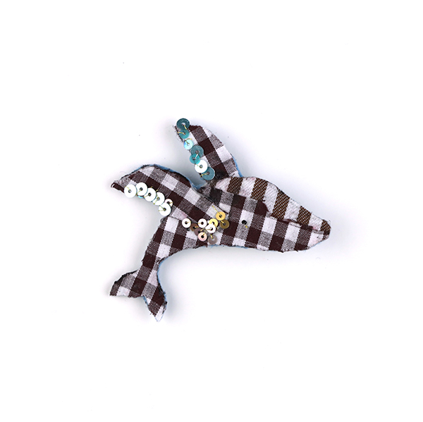 B627 くじらのジャンプ<br>制作者:Ki<br>サイズ:7.4cm×6.4cm<br>素材:フェルト、布、刺繡糸、金・銀糸、ビーズ、スパンコール、ブローチピン<br><br>くじらのブリーチング。スパンコールは泡を表現。