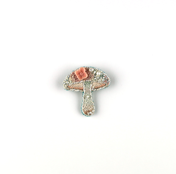 B637 土に還る‶桃花″<br>制作者:itoco<br>サイズ:3.7cm×3.5cm<br>素材: フェルト、刺繍糸、組紐、ビーズ、淡水パール、樹脂パーツ、合成皮革、ブローチピン<br><br>ほんのり桃色に染まったキノコです。