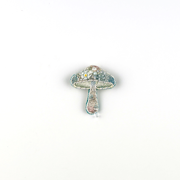 B665 土に還る‶木春菊″<br>制作者:itoco<br>サイズ:4.3cm×3.5cm<br>素材: フェルト、刺繍糸、組紐、ビーズ、淡水パール、プラスチックパーツ、合成皮革、ブローチピン<br><br>木春菊はマーガレットの和名です。秋から春にかけて咲く小さなこの花が好きです。