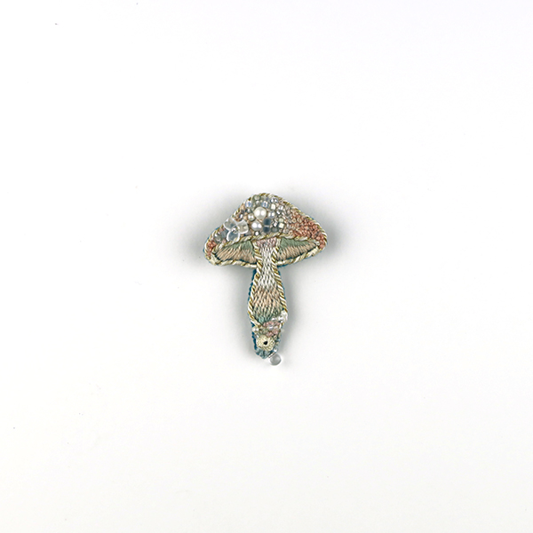 B669 土に還る‶浮島″<br>制作者:itoco<br>サイズ:4.6cm×3.3cm<br>素材: フェルト、刺繍糸、組紐、ビーズ、淡水パール、プラスチックパーツ、合成皮革、ブローチピン<br><br>雲の上をさまよう、きのこの形の小さな島。