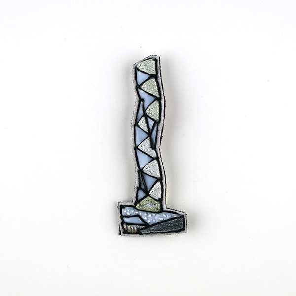 B696 タワーブローチ〈ホワイト×ブラック〉<br>制作者:Kimiko Sekine<br>サイズ:7cm×2.5cm<br>素材:布、PPシート、フェルト、刺繍糸、ブローチピン<br><br>水戸芸術館のタワーはいつも変わらず佇んでいますが、いつも違ってみえます。このブローチは、Art Tower Mitoのシンボルタワーをイメージして作りました。