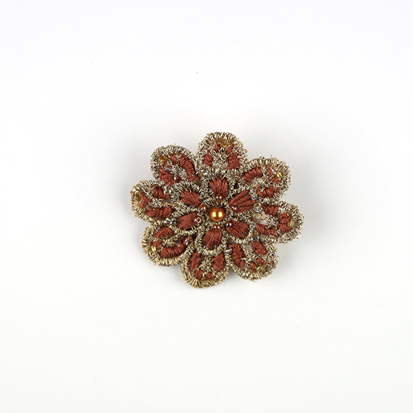 B705 花のブローチ(ゴールド×ペールオレンジ)<br>制作者:KAORI<br>サイズ:5cm×5cm<br>素材:フェルト、刺繍糸、レース、ビーズ、ブローチピン<br><br>レース地に色々な糸とビーズの組み合わせを楽しんでできたブローチです。