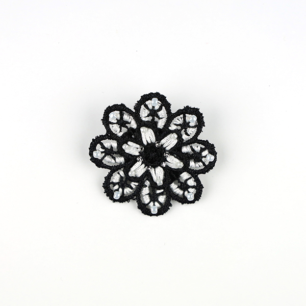 B711 花のブローチ(黒×白)<br>制作者:KAORI<br>サイズ:5cm×5cm<br>素材:フェルト、刺繍糸、レース、ビーズ、ブローチピン<br><br>レース地に色々な糸とビーズの組み合わせを楽しんでできたブローチです。